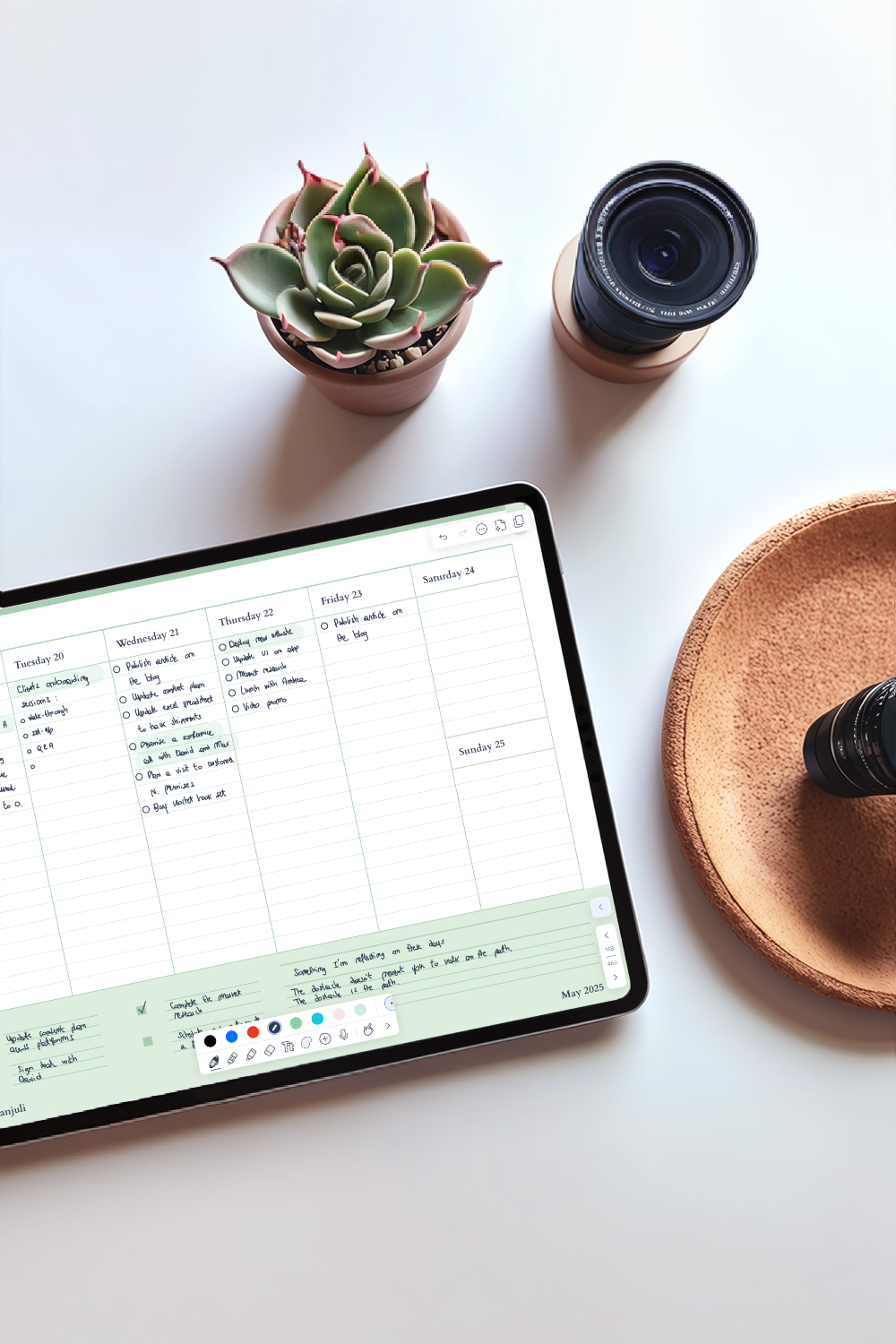 A digital planner open on an iPad laid on a table with a plant nearby