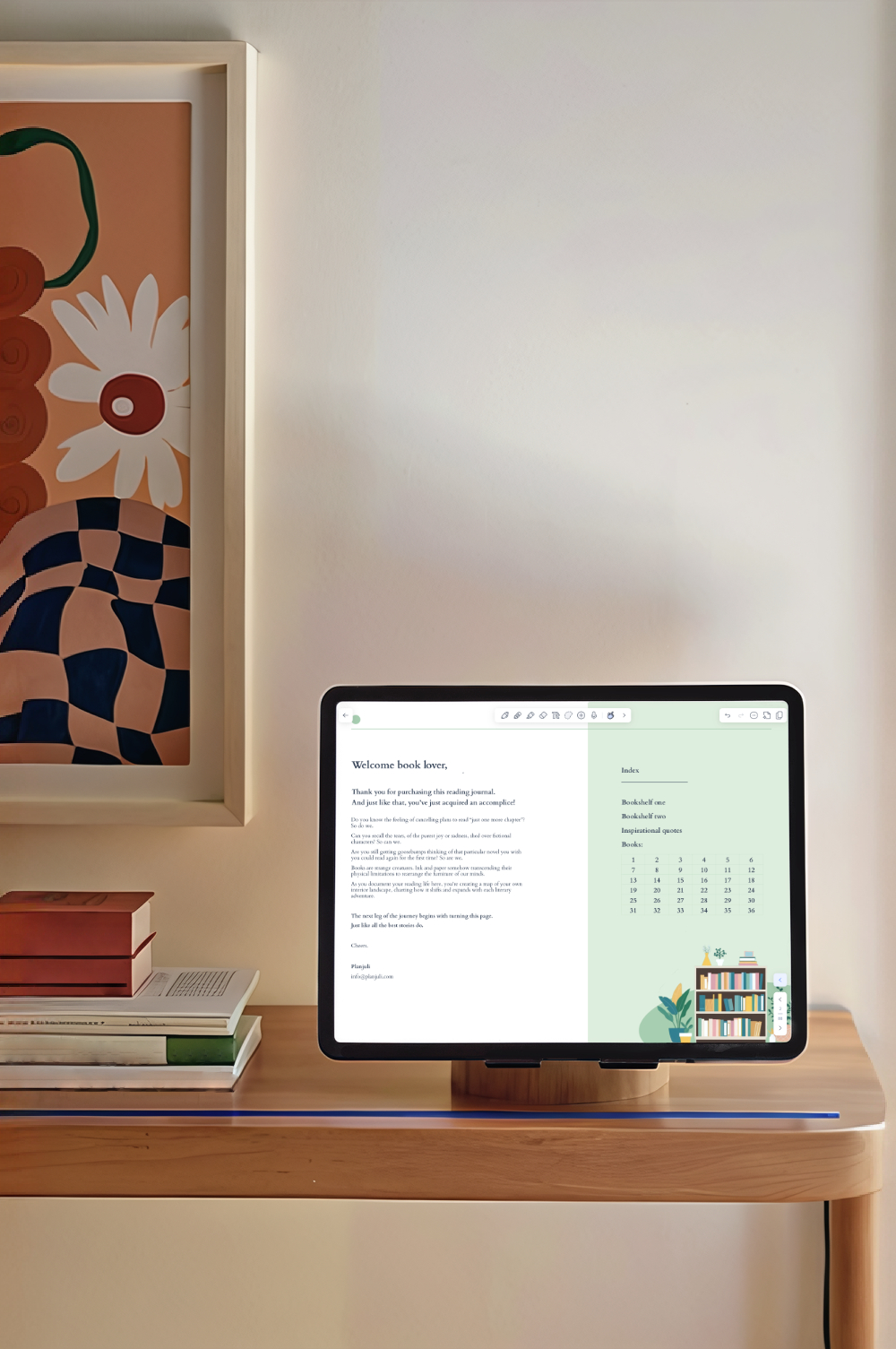 Beautiful photo of an ipad on a stand, open on the index page of Planjuli's reading journal